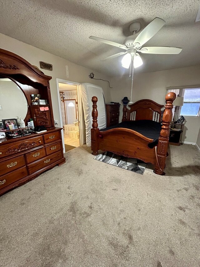 carpeted bedroom featuring ensuite bathroom, ceiling fan, and a textured ceiling