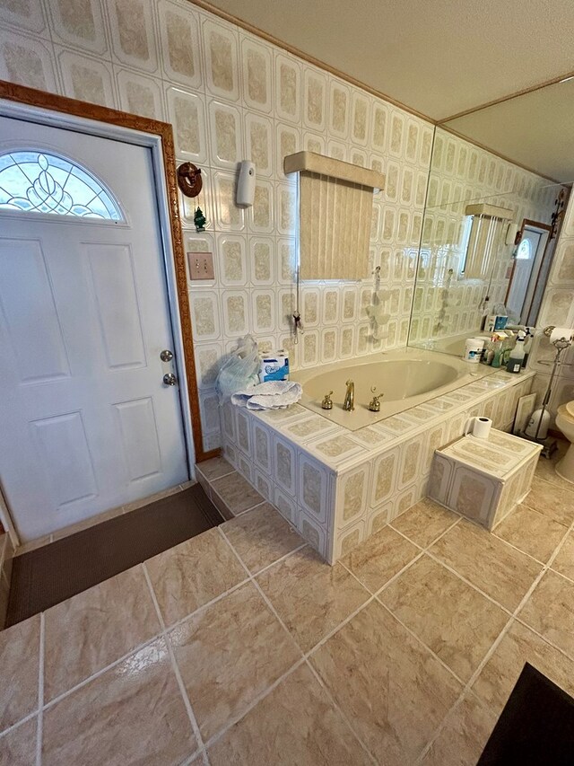 bathroom featuring a relaxing tiled tub and tile patterned floors