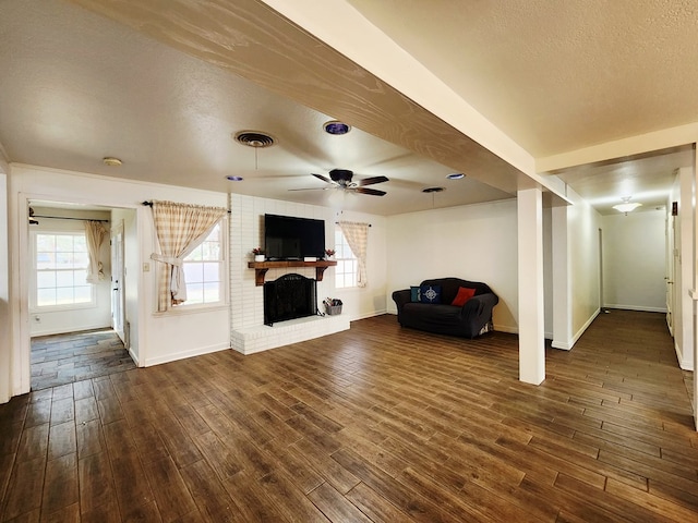 2824 Cimmaron Ave, Midland, TX 79705 - unfurnished living room with baseboards, dark wood finished floors, ceiling fan, a fireplace, and plenty of natural light