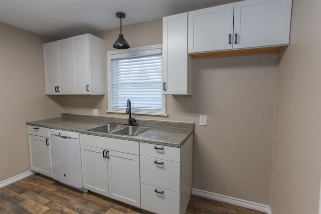 kitchen with baseboards, dishwasher, dark wood-type flooring, and a sink