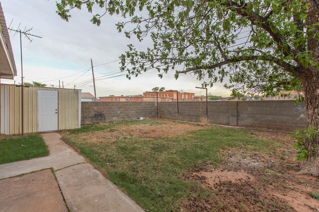 view of yard featuring an outbuilding, a shed, and a fenced backyard