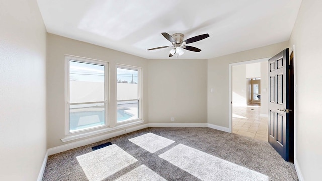 spare room featuring light colored carpet and ceiling fan