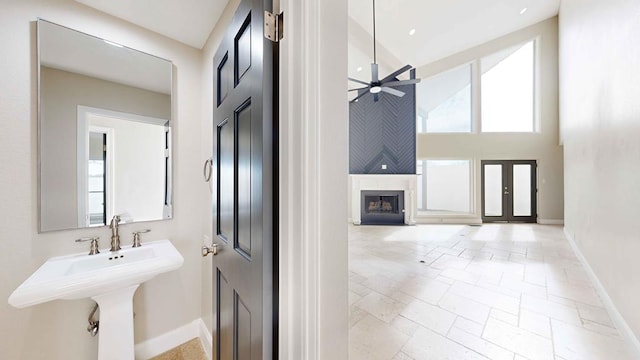 bathroom with a towering ceiling and ceiling fan