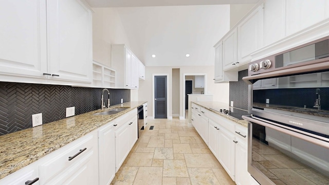 kitchen with white cabinetry, sink, light stone counters, and black appliances