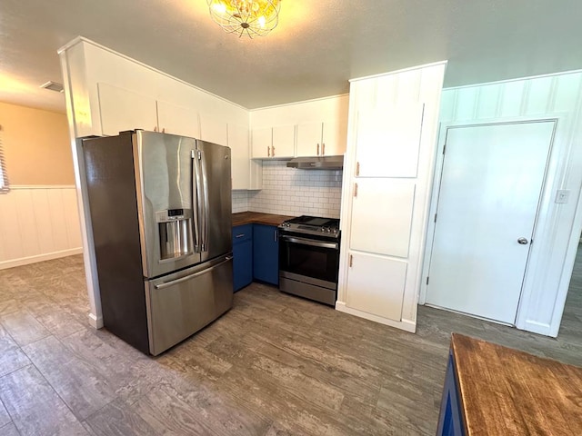 909 Douglas Ave, Midland, TX 79701 - kitchen featuring appliances with stainless steel finishes, blue cabinetry, butcher block countertops, under cabinet range hood, and dark wood finished floors