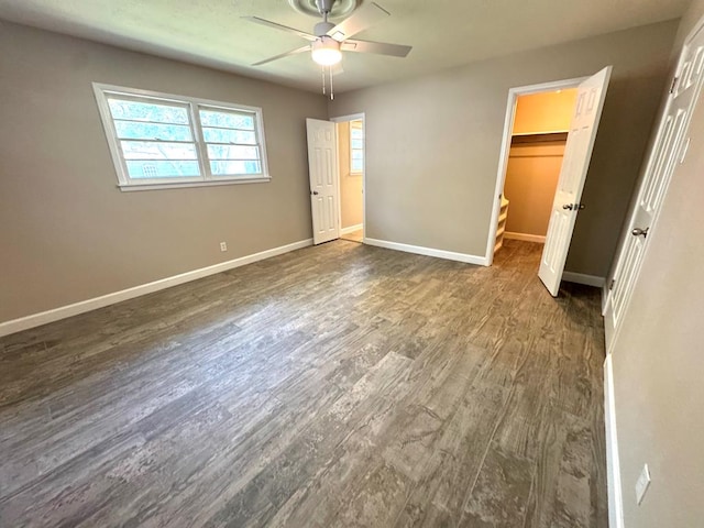909 Douglas Ave, Midland, TX 79701 - unfurnished bedroom featuring dark wood-type flooring, a spacious closet, a closet, and ceiling fan