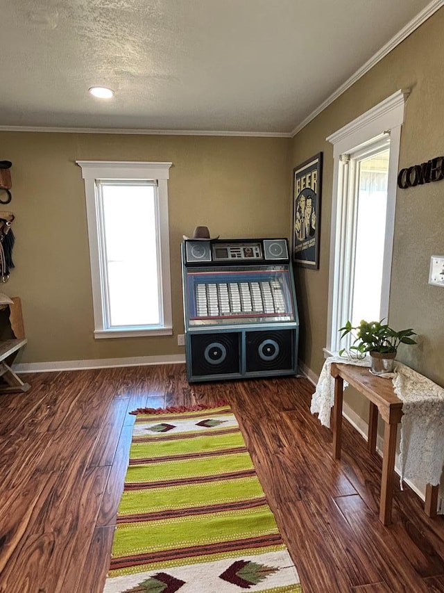 bedroom featuring crown molding, multiple windows, wood finished floors, and baseboards