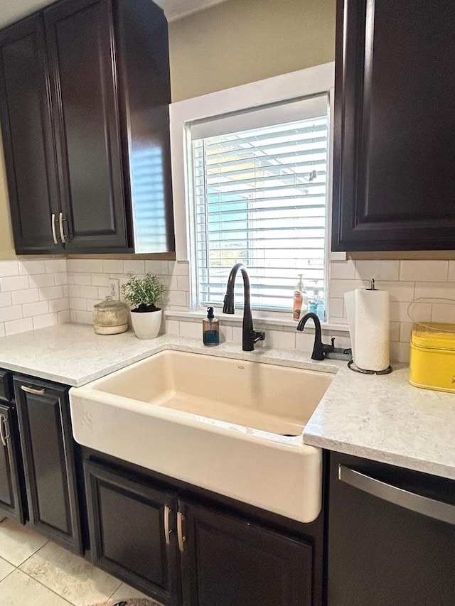 kitchen with a sink, light countertops, and dark cabinets