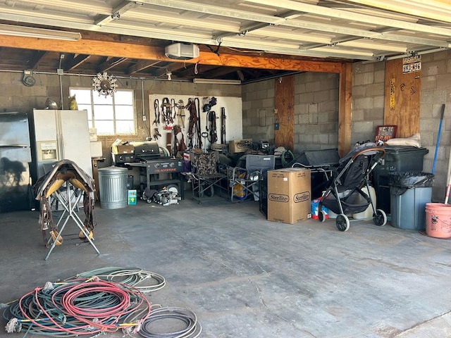 garage with a garage door opener and concrete block wall