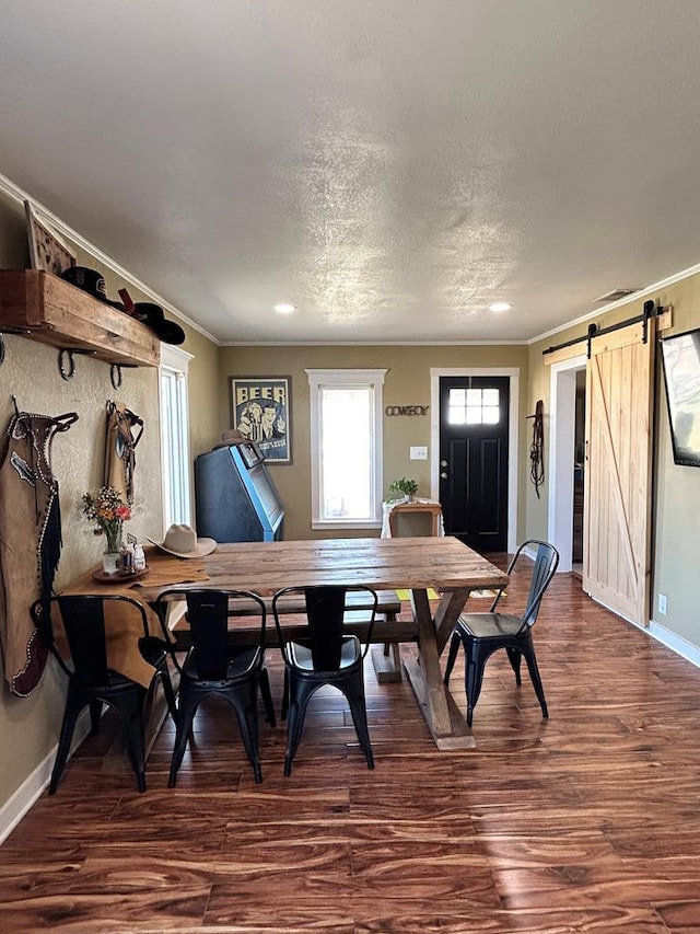 dining area with a barn door, baseboards, dark wood-style floors, and ornamental molding