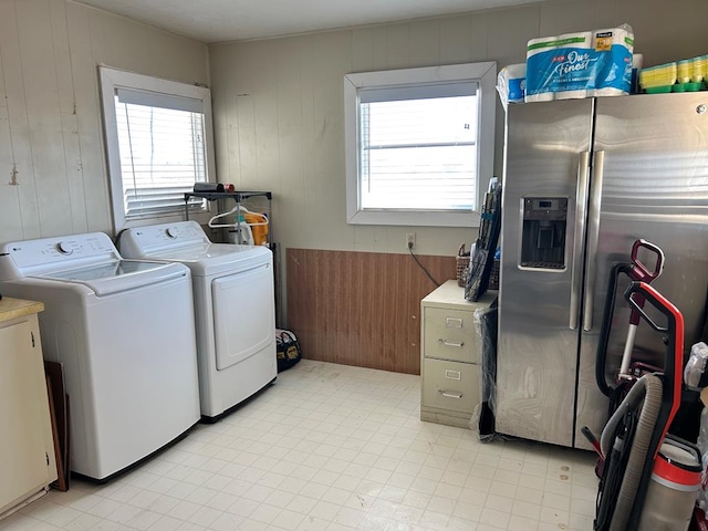 washroom with laundry area, washing machine and dryer, and light floors