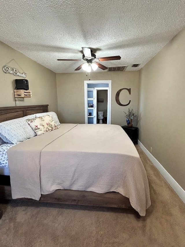 bedroom featuring visible vents, a textured ceiling, carpet flooring, baseboards, and ceiling fan