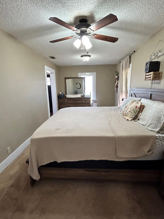 bedroom featuring carpet flooring, a textured ceiling, baseboards, and a ceiling fan