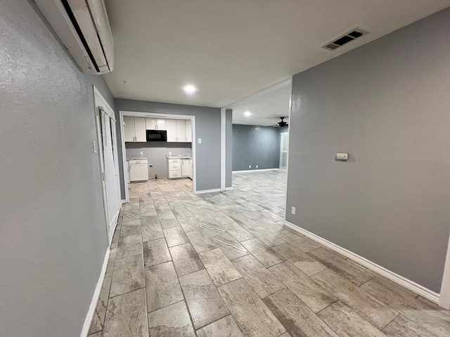 614 W Nobles Ave, Midland, TX 79701 - kitchen featuring black microwave, white cabinets, a wall unit AC, open floor plan, and baseboards