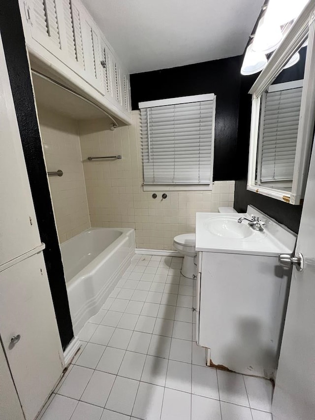 614 W Nobles Ave, Midland, TX 79701 - bathroom featuring tile patterned floors, a bathtub, vanity, toilet, and tile walls