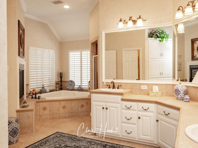 bathroom featuring a stall shower, ornamental molding, vaulted ceiling, a garden tub, and tile patterned floors