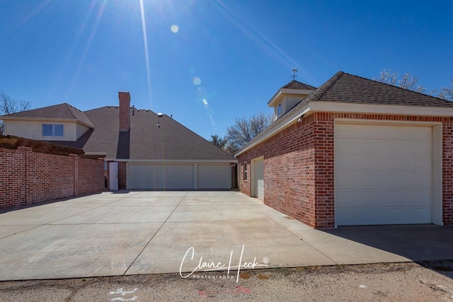 view of property exterior featuring brick siding, an attached garage, and concrete driveway