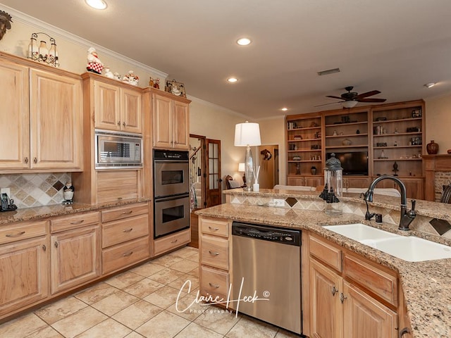 kitchen with light brown cabinets, ornamental molding, appliances with stainless steel finishes, and a sink