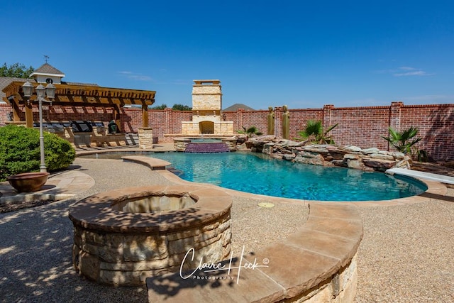 view of pool with a pool with connected hot tub, a pergola, fence, a diving board, and a patio area