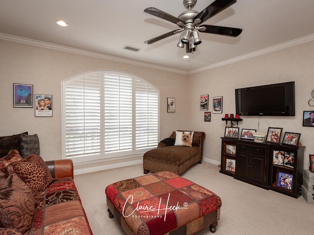 carpeted living room featuring visible vents, baseboards, crown molding, and a ceiling fan