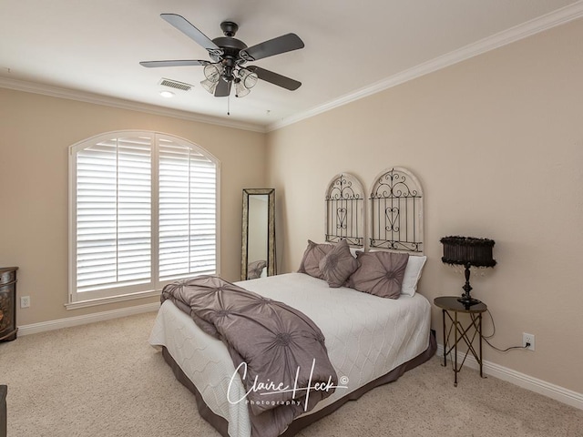 carpeted bedroom featuring a ceiling fan, baseboards, visible vents, and ornamental molding