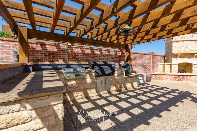 view of patio featuring an outdoor kitchen, a pergola, an outdoor stone fireplace, ceiling fan, and a grill