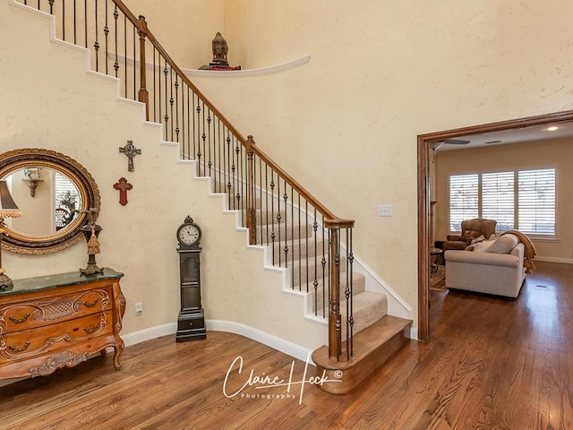 staircase with baseboards and wood finished floors