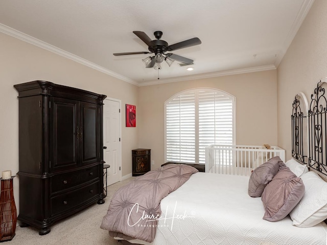 carpeted bedroom featuring ceiling fan and crown molding