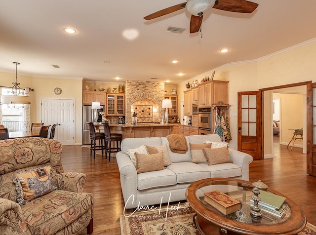 living room with visible vents, a ceiling fan, wood finished floors, recessed lighting, and crown molding