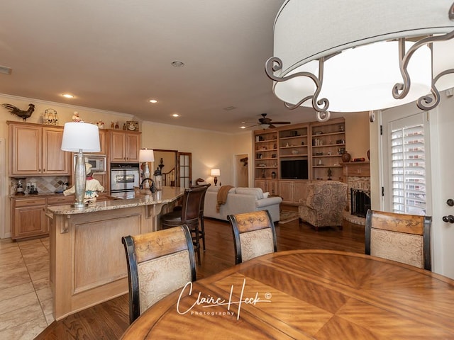 dining space featuring visible vents, a brick fireplace, crown molding, recessed lighting, and a ceiling fan