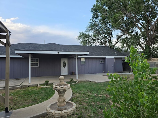 ranch-style home with a patio, a front yard, and roof with shingles