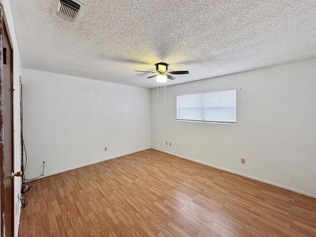 empty room featuring ceiling fan, a textured ceiling, and light wood-type flooring