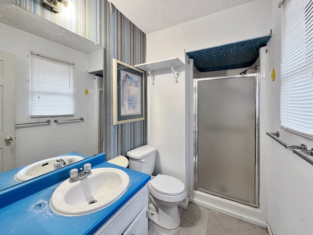 bathroom with tile patterned flooring, vanity, toilet, a shower with door, and a textured ceiling