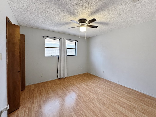 spare room featuring a textured ceiling, ceiling fan, and light hardwood / wood-style flooring