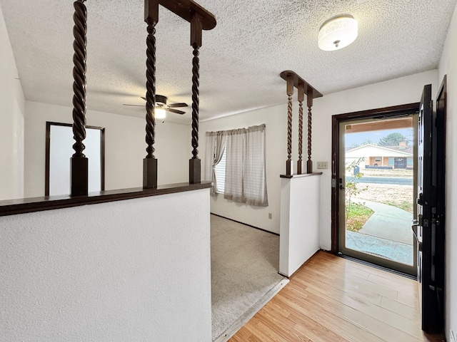 foyer featuring a textured ceiling, ceiling fan, and light wood-type flooring