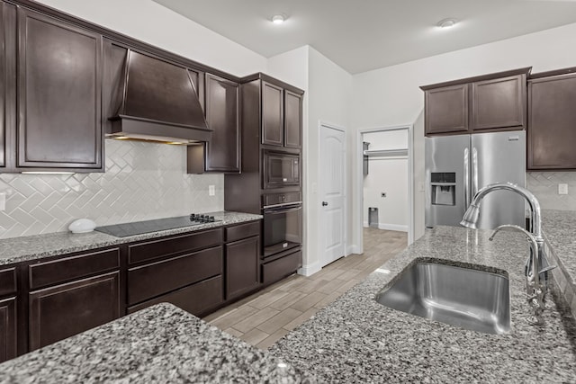 1306 Randolph Ln, Midland, TX 79705 - kitchen with a sink, black appliances, custom exhaust hood, light stone countertops, and backsplash