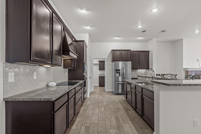1306 Randolph Ln, Midland, TX 79705 - kitchen featuring stainless steel fridge with ice dispenser, dark brown cabinetry, range hood, black electric stovetop, and a sink