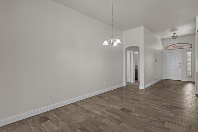 1306 Randolph Ln, Midland, TX 79705 - foyer entrance with arched walkways, a chandelier, dark wood finished floors, and baseboards