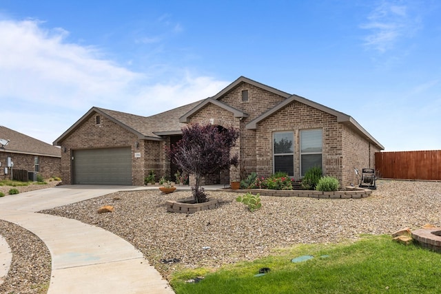 1306 Randolph Ln, Midland, TX 79705 - view of front facade featuring brick siding, driveway, an attached garage, and central AC unit
