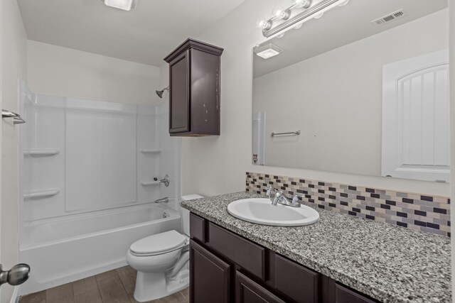 1306 Randolph Ln, Midland, TX 79705 - bathroom with decorative backsplash, vanity, toilet, shower / washtub combination, and wood finished floors