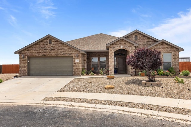 1306 Randolph Ln, Midland, TX 79705 - view of front of house featuring brick siding, driveway, an attached garage, and a shingled roof