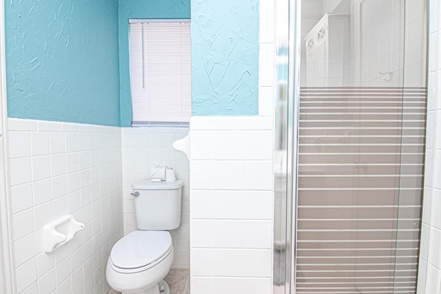 bathroom featuring toilet and tile walls