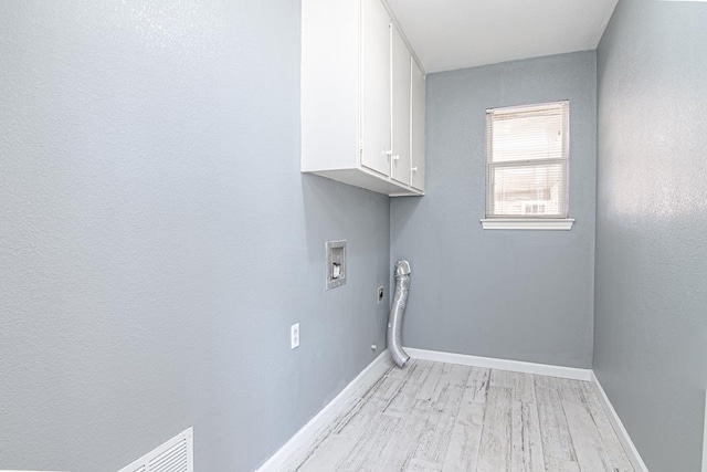 laundry area featuring hookup for a washing machine, cabinets, and light wood-type flooring