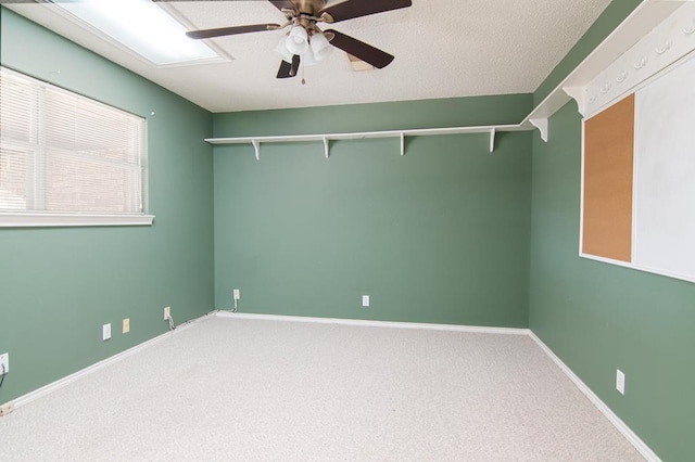 carpeted spare room with a textured ceiling and ceiling fan