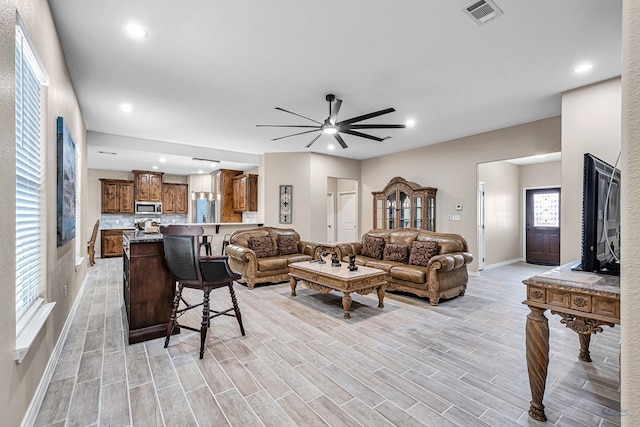 living room featuring light wood-type flooring and ceiling fan