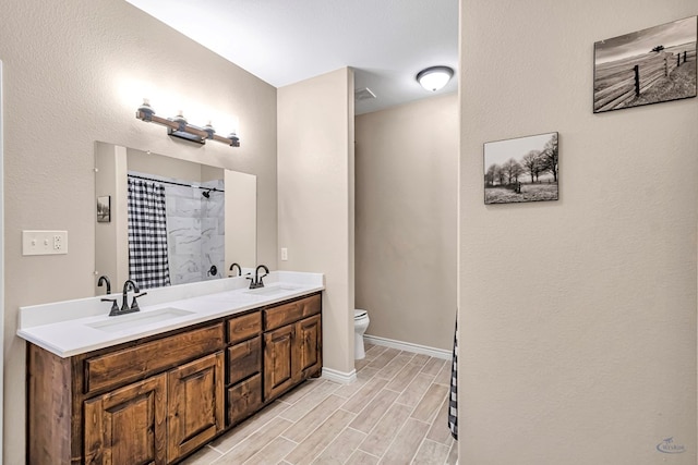 bathroom with vanity, toilet, and curtained shower