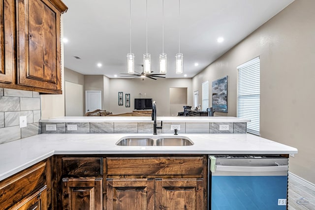 kitchen with backsplash, ceiling fan, sink, decorative light fixtures, and dishwasher