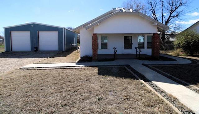 view of front of property featuring a porch, a garage, and an outdoor structure