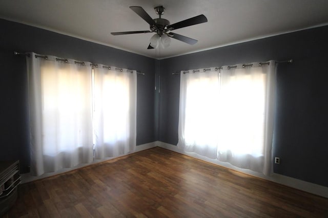 spare room featuring ceiling fan and dark wood-type flooring