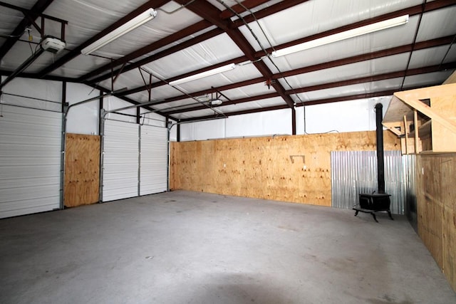 garage with a garage door opener and a wood stove